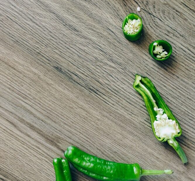 Šviežios žalios chalapos paprikos ant pjaustymo lentelės ruošiamos maisto gamybai.